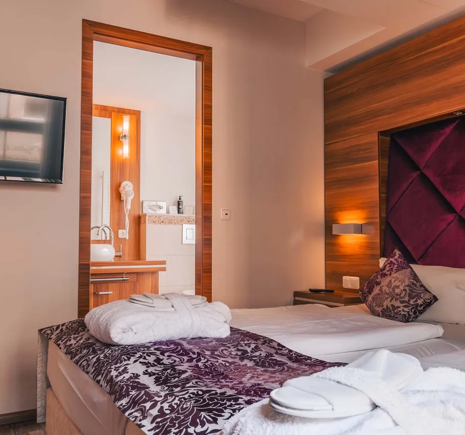 Doppelzimmer in der Ferienwohnung in Binz auf Rügen mit Doppelbett und Blick auf das angrenzende Bad.
