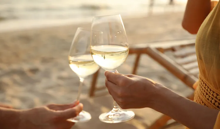 Paar genießt Wein am Ostseestrand bei den Arkona Strandresidenzen in Binz – Beispiel für gelebte Gast-Nachhaltigkeit