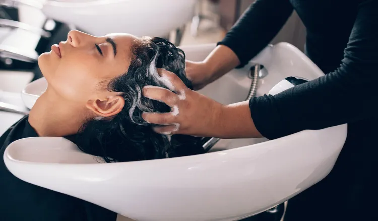 Eine Frau genießt beim Friseur Figaro auf Rügen eine entspannende Kopfmassage beim Haare waschen.