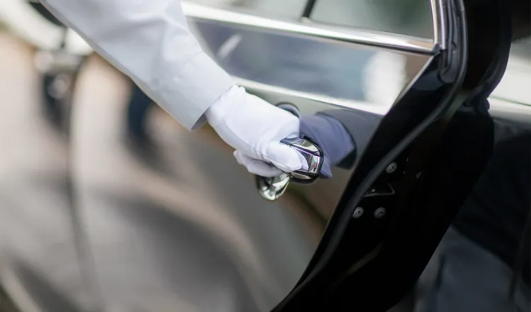 Unser Limousinenservice öffnet die Tür einer unser erstklassigen Limousinen für einen komfortablen Transport.