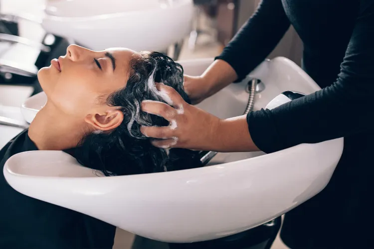 Eine Frau genießt beim Friseur Figaro auf Rügen eine entspannende Kopfmassage beim Haare waschen.