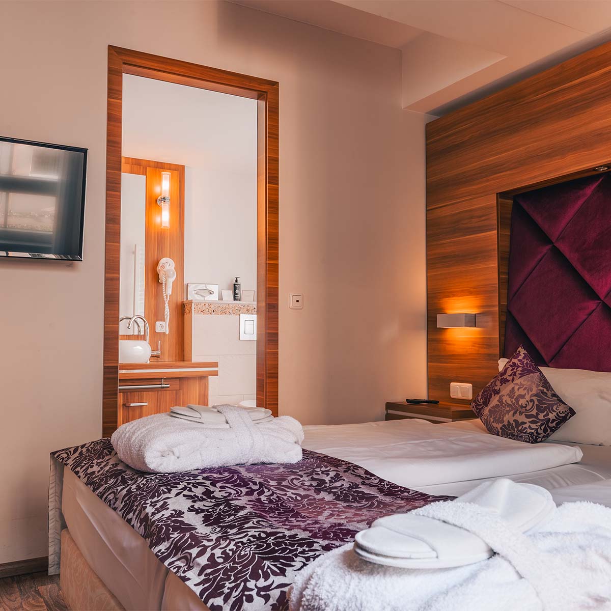 Doppelzimmer in der Ferienwohnung in Binz auf Rügen mit Doppelbett und Blick auf das angrenzende Bad.
