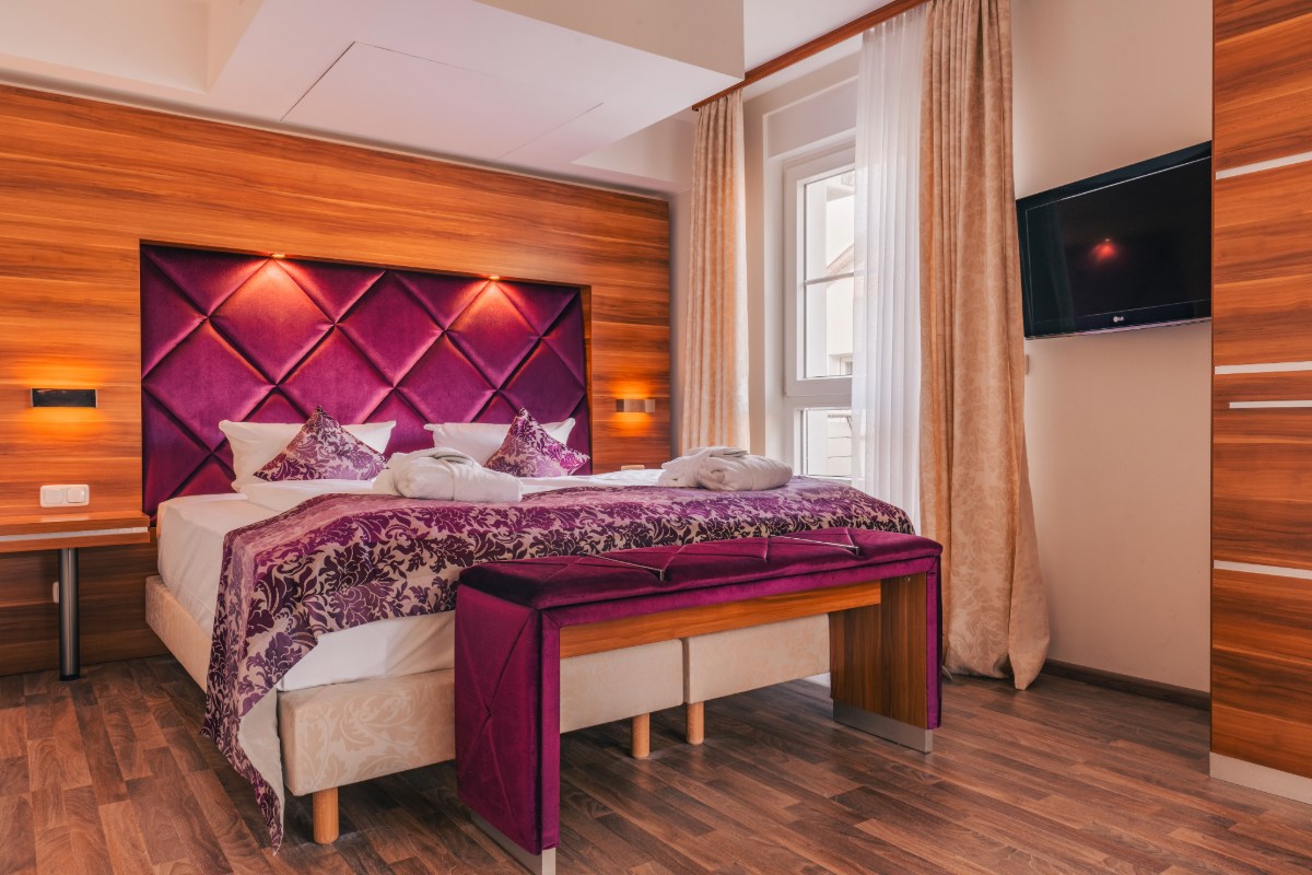 A luxurious apartment with a spacious and comfortable double bed and TV on the wall by the Baltic Sea.
