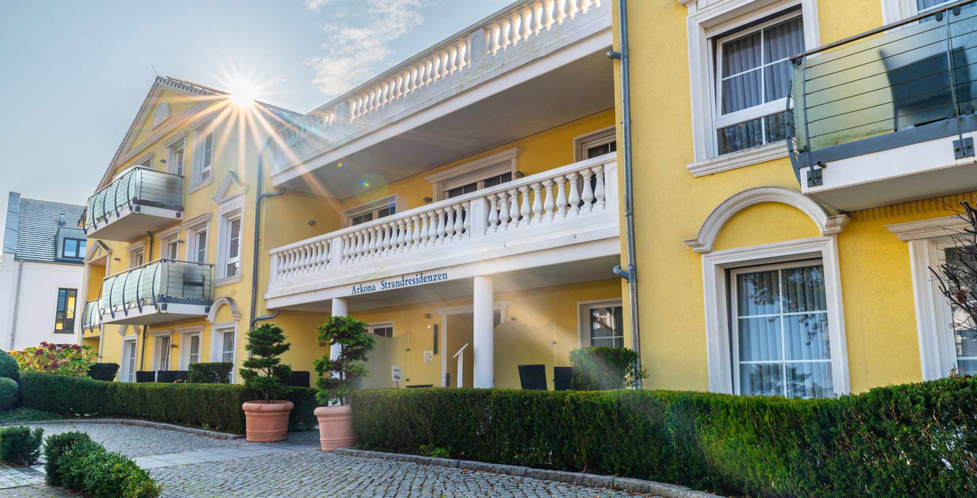 Außenansicht des Apartment Hotel auf Rügen mit großer Balkonfläche bei schönem Wetter.
