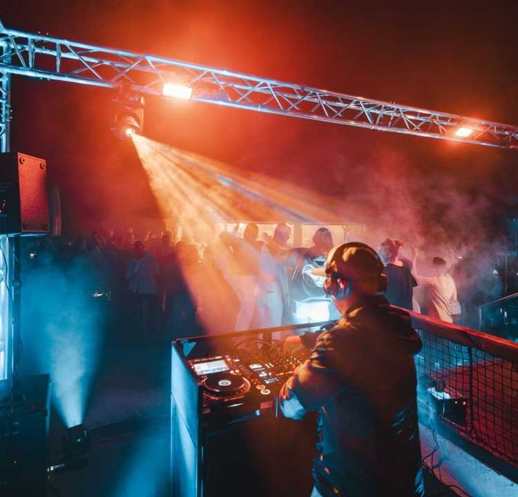 DJ an Turntables bei der Langen Nacht mit Lichtshow und Publikum in der Sky Bar Binz auf Rügen