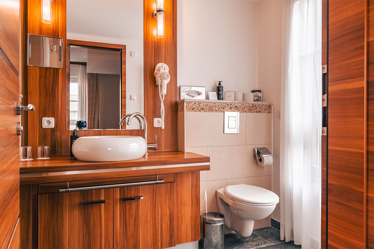 Badezimmer im Apartment der Arkona Strandresidenzen Binz mit Waschbecken, WC und großem Spiegel
