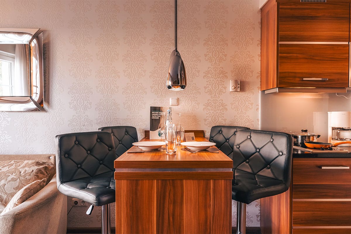 Esstisch im Deluxe Apartment der Arkona Strandresidenzen Binz mit Gedeck für zwei und moderner Wanddekoration
