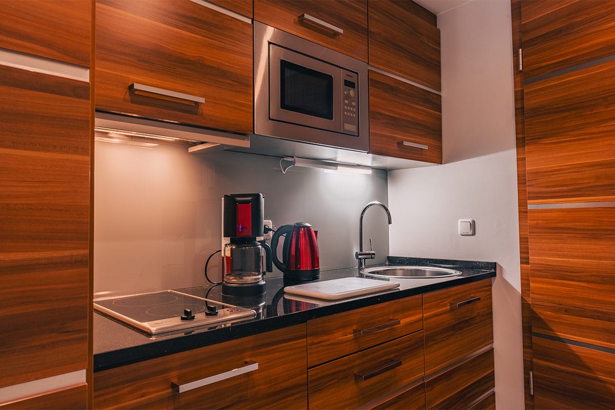 Moderne Küchenzeile im Suite Apartment der Arkona Strandresidenzen Binz mit Mikrowelle, Wasserkocher und Kaffeemaschine