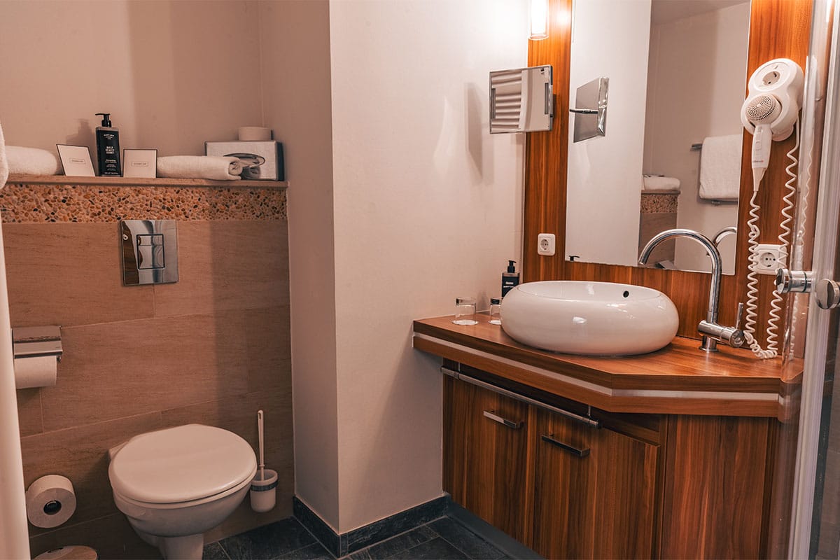 Badezimmer im Suite Apartment der Arkona Strandresidenzen Binz mit Waschtisch, Spiegel und Toilette