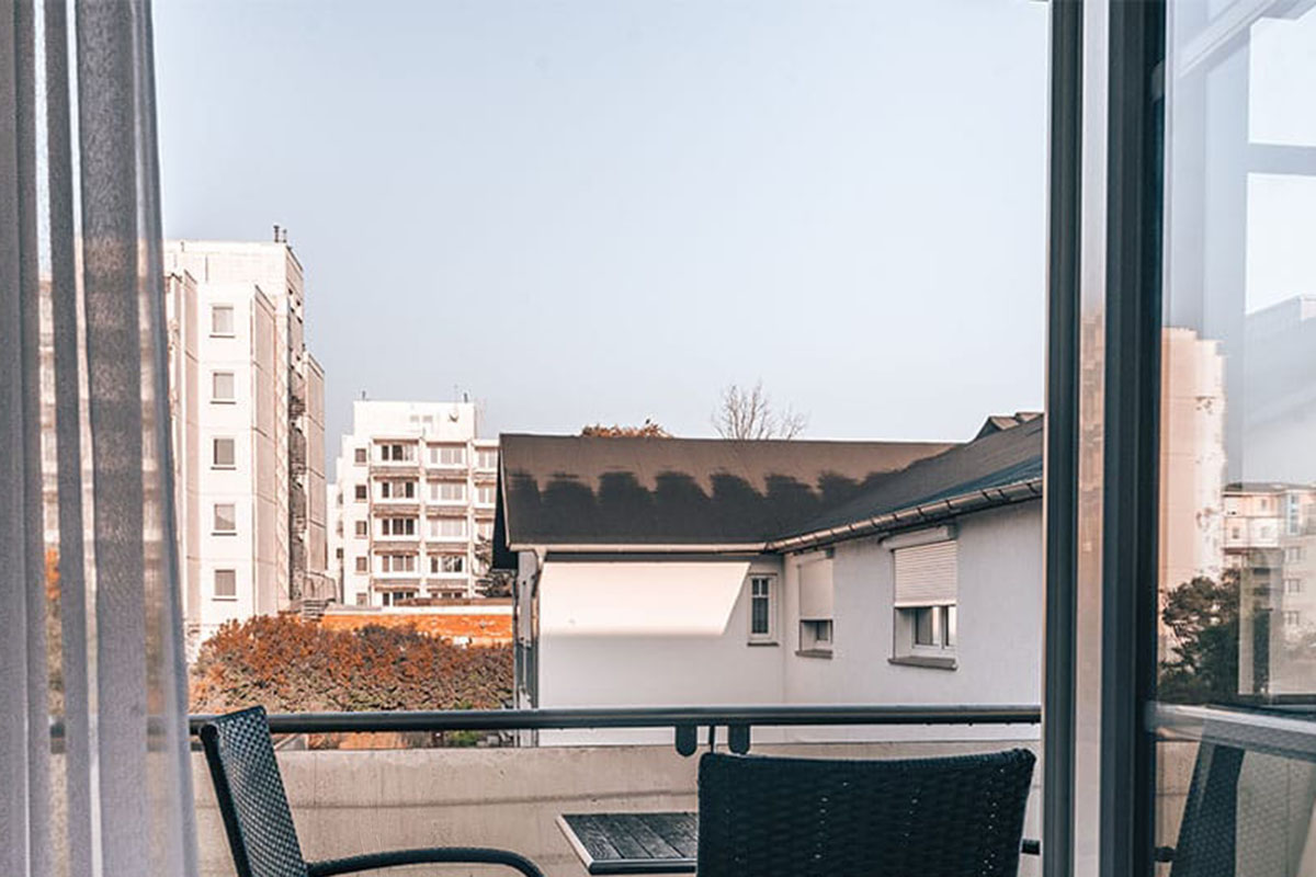 Blick vom Balkon mit Sitzmöbeln auf umliegende Gebäude im Studio der Arkona Strandresidenzen