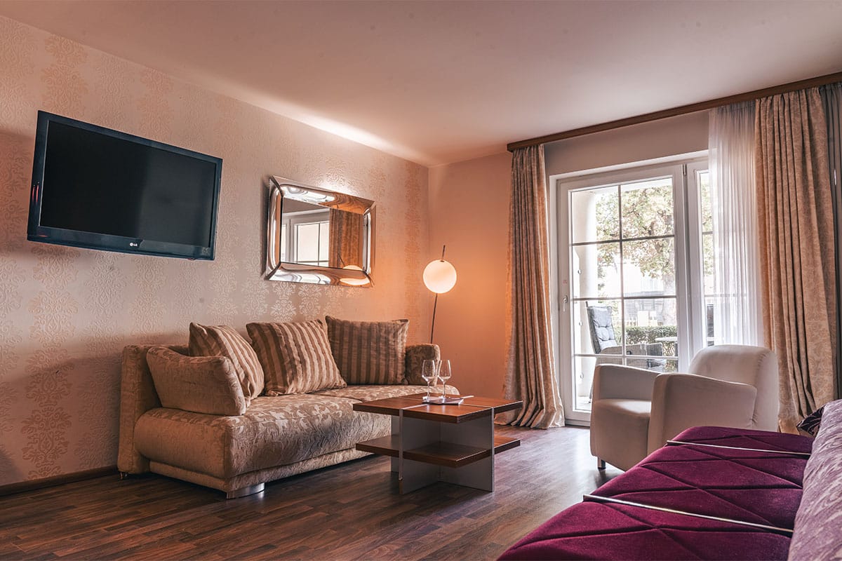 Sofa mit Beistelltisch und bodentiefem Fenster im Superior Studio der Arkona Strandresidenzen Binz