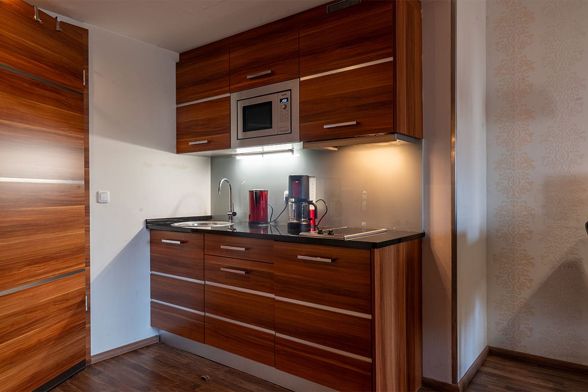 Moderne Küchenzeile mit Spüle, Kaffeemaschine und Mikrowelle im Superior Studio der Arkona Strandresidenzen Binz